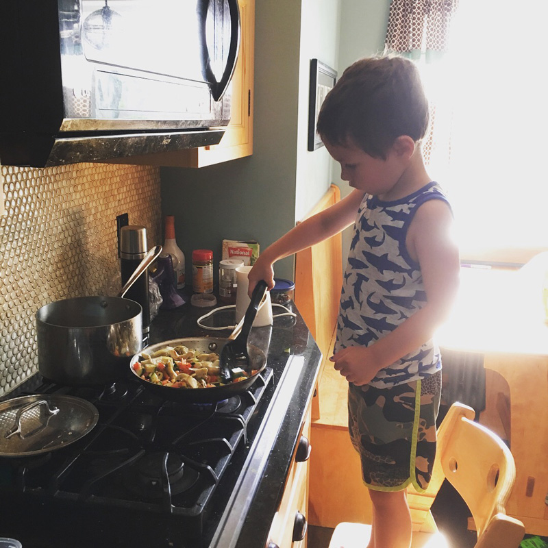 A child cooking dinner at the stove